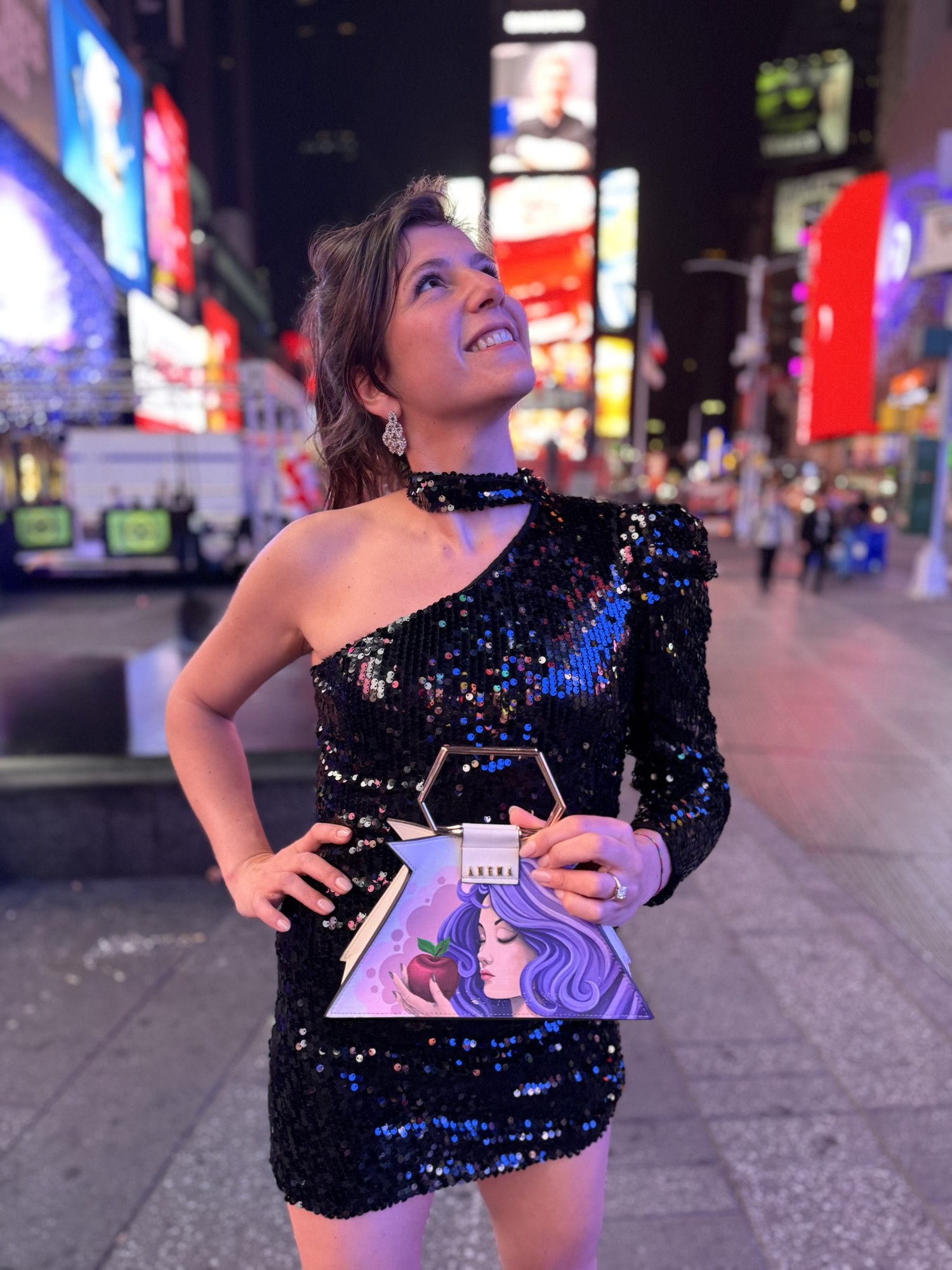 Benedetta di sera con borsa decorata con un volto
