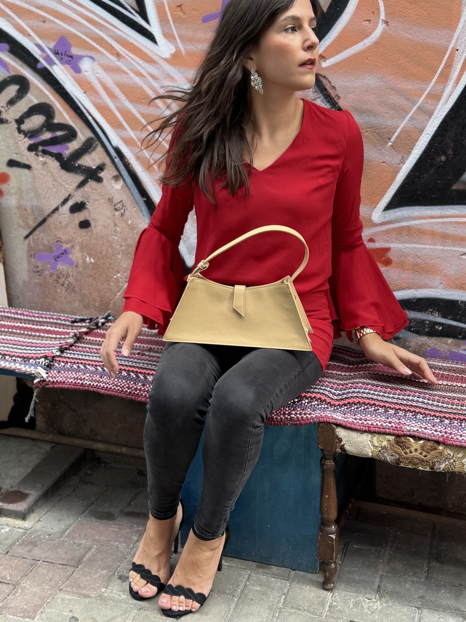 Benedetta in blusa rossa seduta con borsa chiara