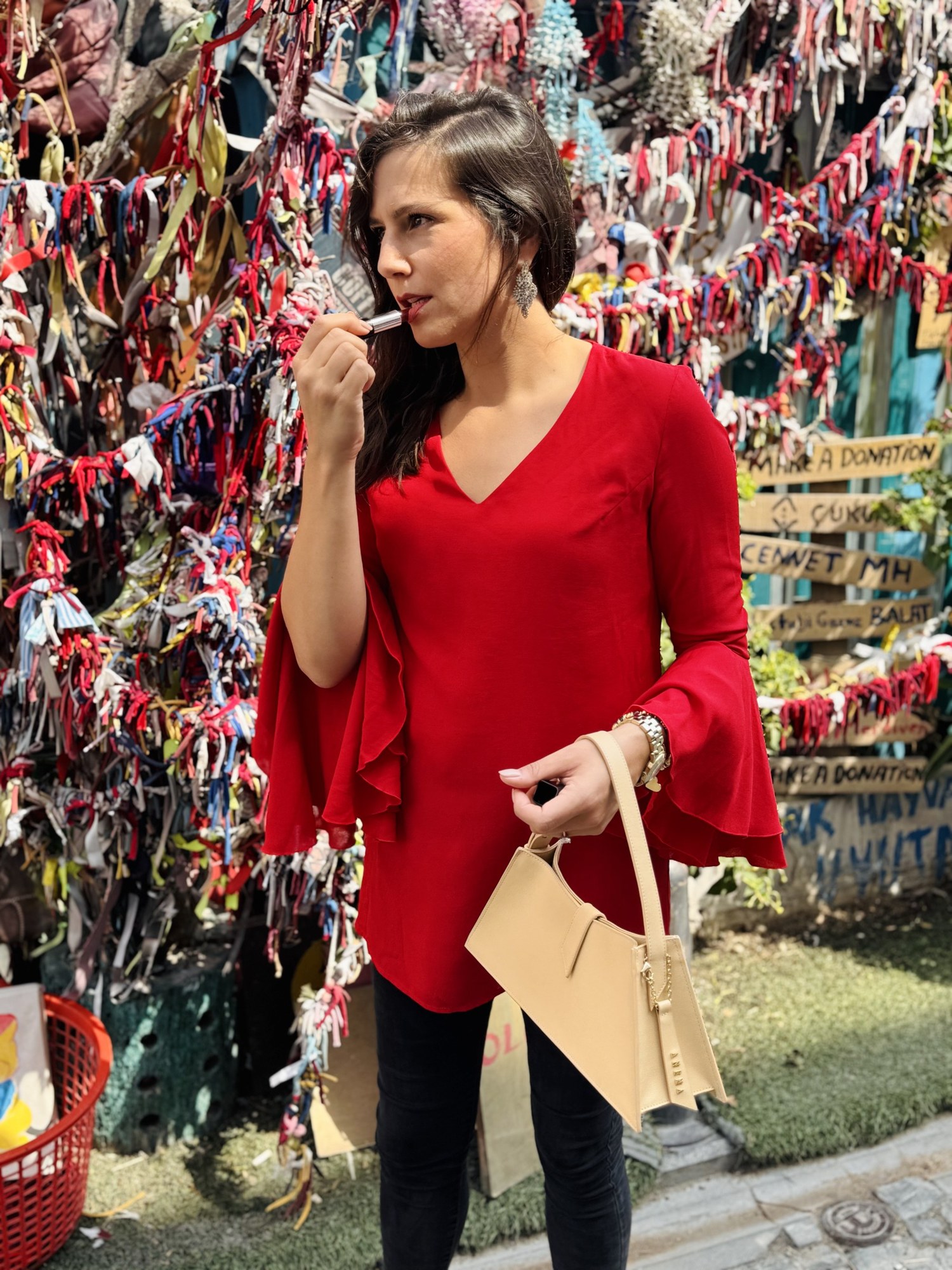 Benedetta in blusa rossa con borsa chiara tra nastri colorati